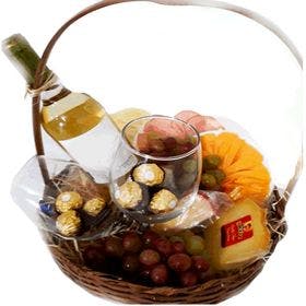 cesta com vinho, uvas, chocolates e tipos de frios 